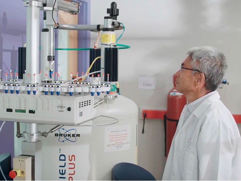 man in white coat working at machine