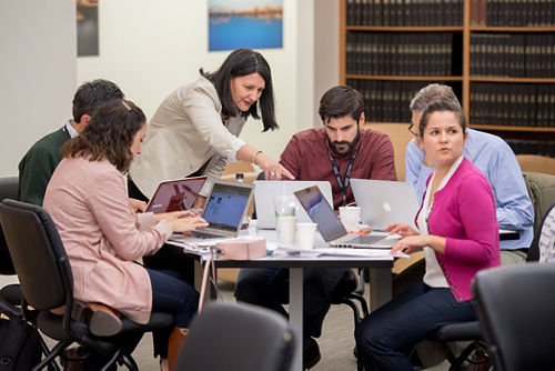 Photo of group of people working at a table.