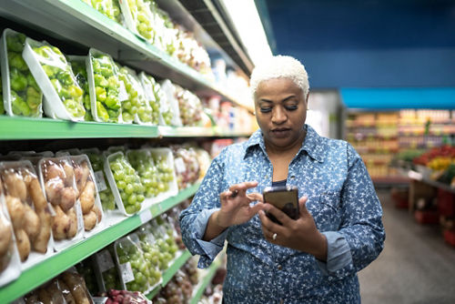 Woman in produce aisle of grocery store 