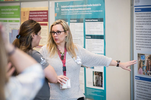 Photo of Dana McLure and another woman discussing a poster
