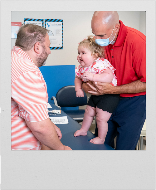 A St. Jude physical therapist works with a patient, while her father cheers her on.
