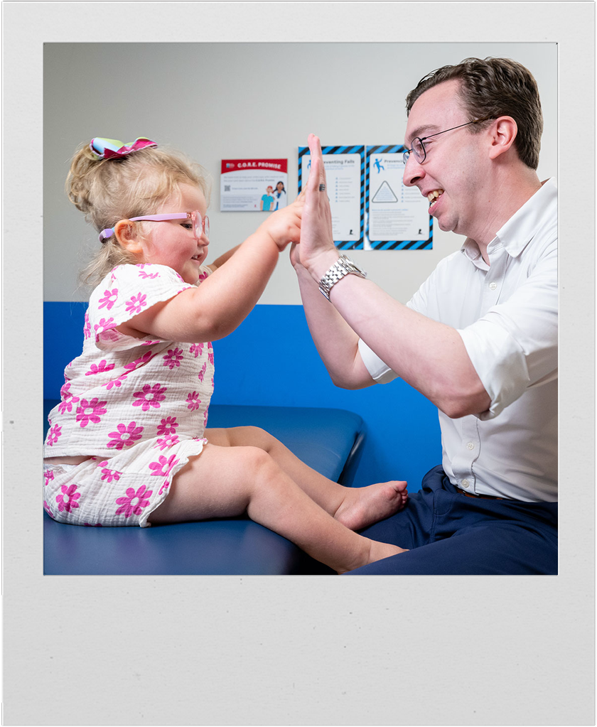 A St. Jude patient plays with Samuel Hughes, Center of Experimental Neurotherapeutics operations manager, during her checkup.