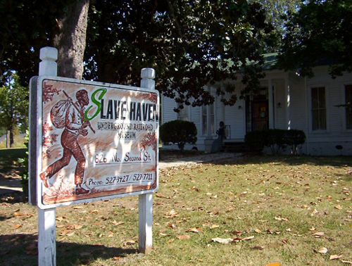 Exterior sign of Slave Haven Underground Railroad Museum in front of white building