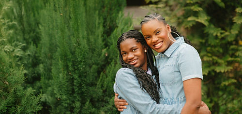 Adult and young adult embracing and smiling