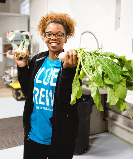 Volunteer holding vegetables