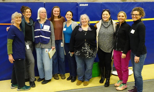 Group of women standing in front of a climbing wall